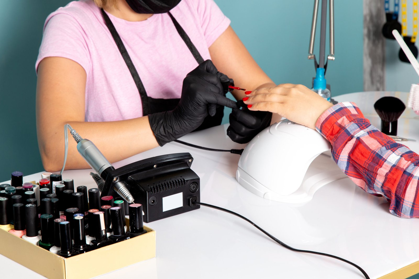 front-view-young-female-manicure-pink-t-shirt-with-black-gloves-black-mask-doing-manicure-blue